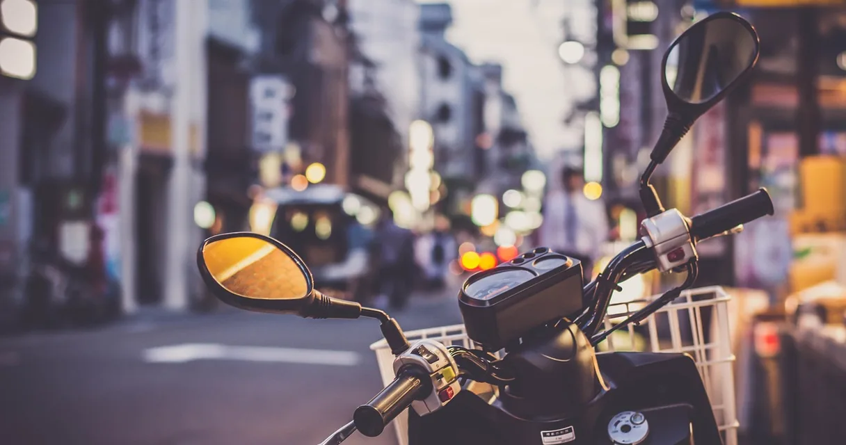 Scooter estacionada em uma rua urbana desfocada, ilustrando o refinanciamento de moto