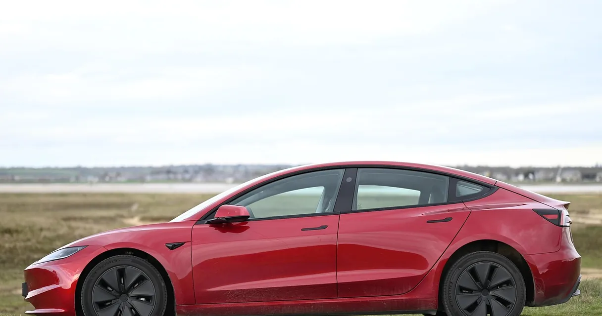 Carro elétrico vermelho estacionado em um campo, ilustrando como funciona um carro híbrido