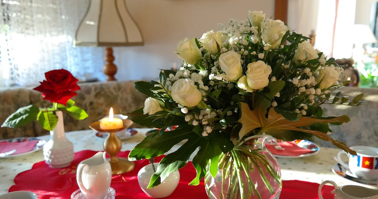 Buquê de rosas brancas ao lado de uma rosa vermelha sobre a mesa, ilustrando como saber se o homem está apaixonado