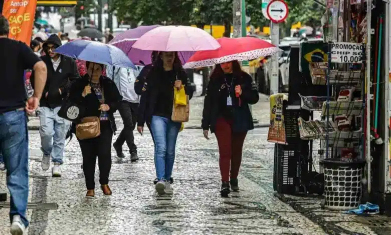 Pessoas pegando chuva e agasalhados