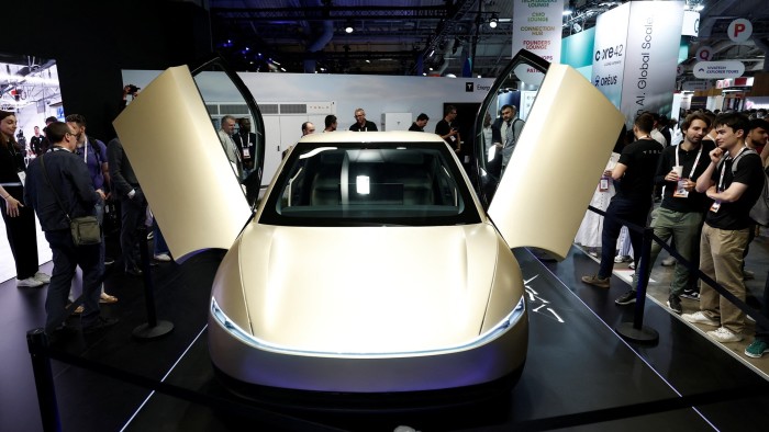 People look at the Tesla Cybercab at a car show in Paris