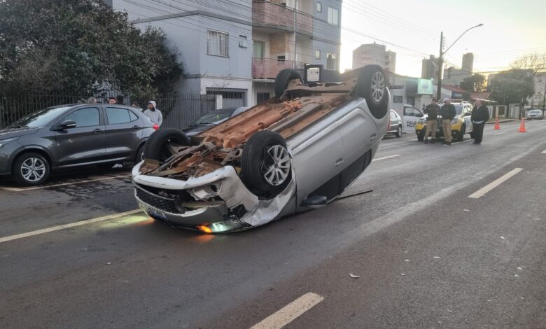 Sandero capota após bater em dois carros estacionados na Rua Presidente Kennedy