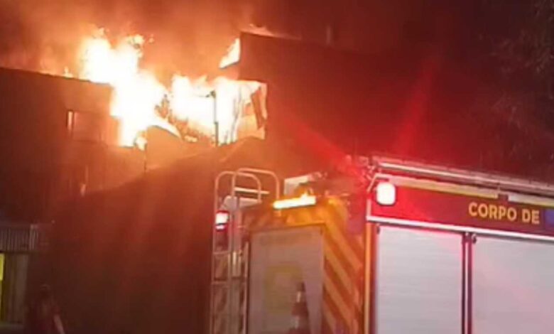 Incêndio atingindo confeitaria e corpo de bombeiros apagando