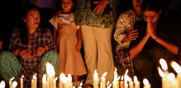 Pessoas acendem velas em homenagem aos mortos durante protestos em Katmandu, no Nepal