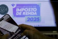 Usuário com o celular e o computador na página da receita federal